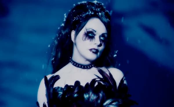 Sarah Brightman as Blind Mag in Repo: The Genetic Opera. She is ghostly pale with large, wispy lashes and dramatic gothic dress.