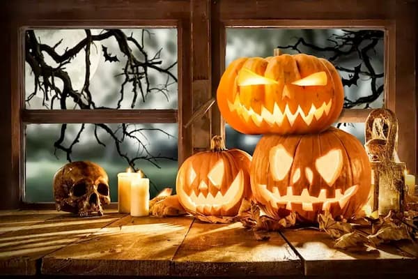 A spooky table setting showing a Jack O Lantern surrounded by Halloween candles
