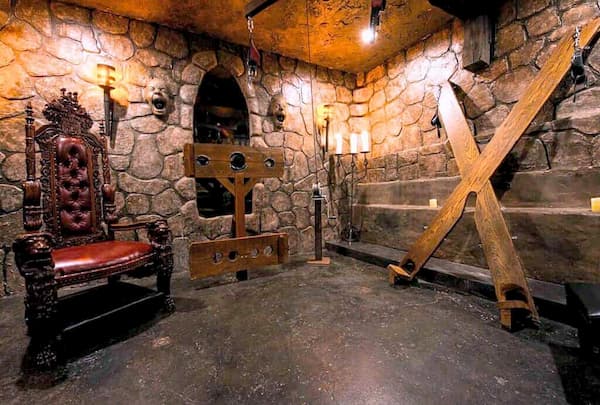 Medieval sex dungeon design featuring stone walls, a throne, stockade, and St. Andrew's Cross.