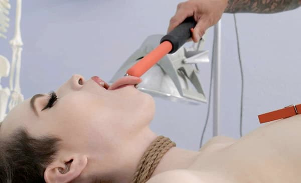A woman in rope bondage sticking out her tongue to receive an electro stimulation shock from a violet wand